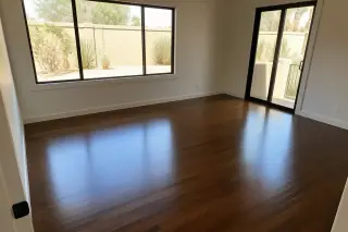Gleaming refinished hardwood flooring in a bedroom with desert views through windows in Phoenix, AZ.