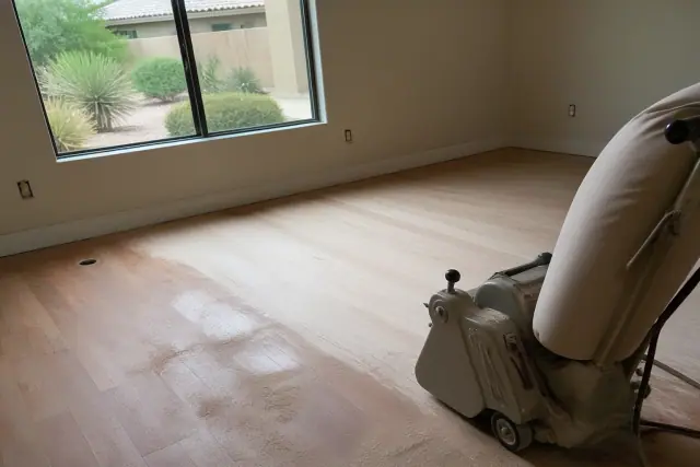Industrial sander smoothing hardwood bedroom floors during a restoration project in Tempe, AZ.