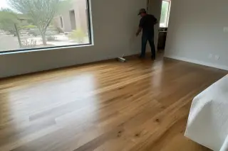 Finished hardwood flooring in a sunlit bedroom with a view of a Phoenix, AZ landscape.