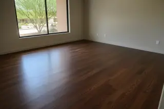 Finished hardwood flooring with visible wood grain and a sun-drenched desert window view in a Phoenix, AZ home.