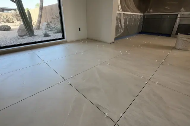 Ceramic tile flooring installation with spacers and view of desert landscaping in a kitchen in Phoenix, AZ.
