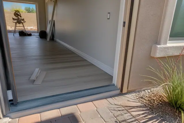 New laminate flooring installation with decorative baseboards in a residential home in Gilbert, AZ.