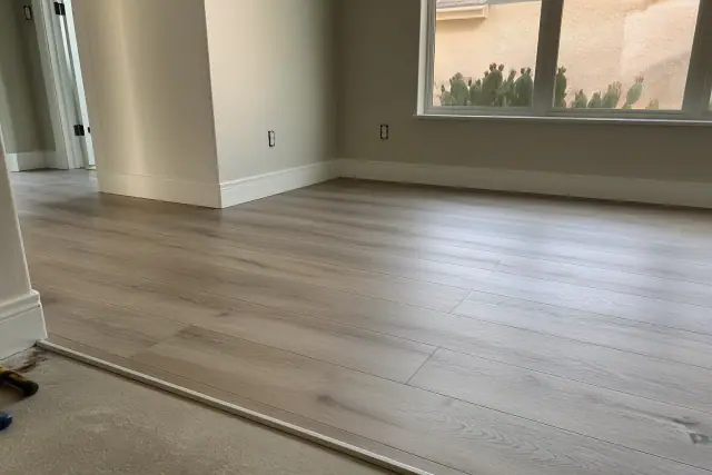 Newly installed laminate flooring with baseboard trim in a Scottsdale, AZ home.