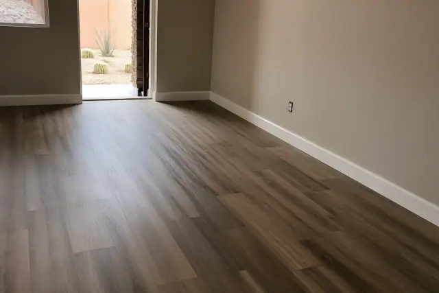 Laminate flooring installation with finished baseboards in a Phoenix, AZ basement.