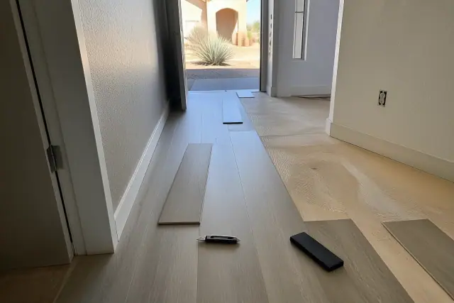 Luxury vinyl plank flooring being installed in a staggered pattern in a hallway in Peoria, AZ.