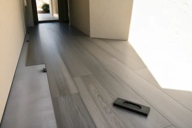 Luxury vinyl plank flooring with staggered seams installed in a Scottsdale, AZ hallway with bright sunlight.