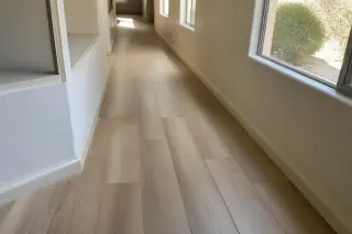 Staggered luxury vinyl plank flooring with wood grain textures in a residential hallway in Phoenix, AZ.
