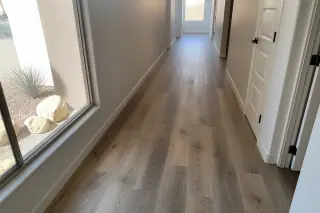 Finished luxury vinyl plank flooring in a narrow corridor with desert views through a window in Phoenix, AZ.