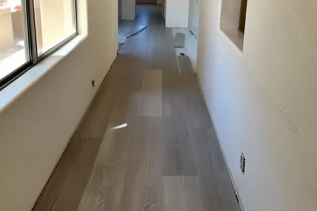 Luxury vinyl plank flooring being installed in a staggered pattern in a hallway in Phoenix, AZ.