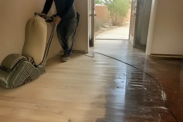 Technician sanding wood flooring to level the subfloor during a renovation in Phoenix, AZ.