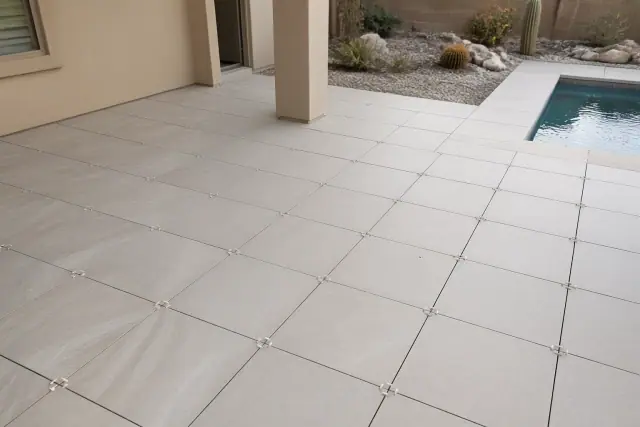 New ceramic outdoor and pool tile flooring with grout lines installed on a residential patio in Phoenix, AZ.