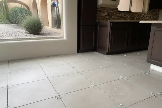 Ceramic tile flooring installation with spacers on a kitchen floor in a Surprise, AZ home.
