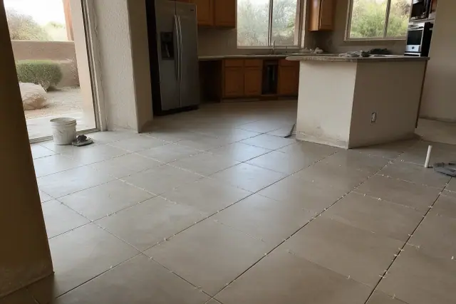 New ceramic kitchen tiles with spacers installed on a floor in Tempe, AZ, with desert scenery visible through the window.