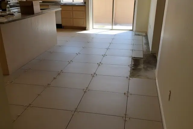 Ceramic floor tiles with alignment spacers in a kitchen in Mesa, AZ.