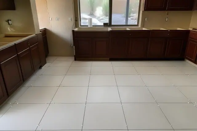 Ceramic tiles with spacers installed on a kitchen floor during a home renovation in Gilbert, AZ.