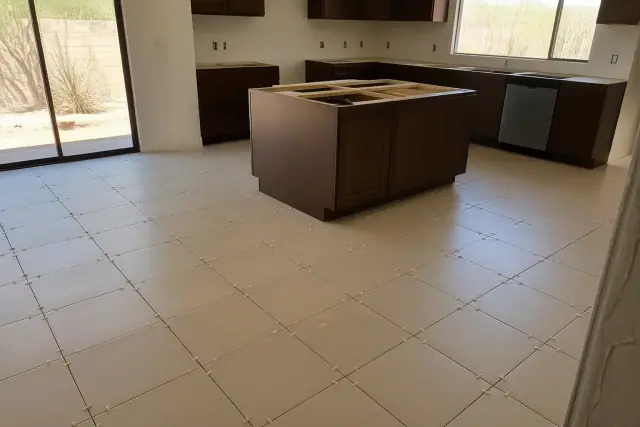 New ceramic floor tiles with spacers aligned on a kitchen floor during installation in Peoria, AZ.