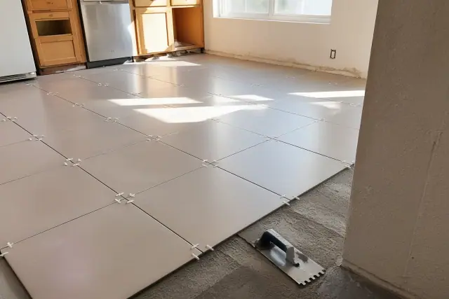 New ceramic tiles being installed with spacers on a kitchen floor during a repair project in Phoenix, AZ.