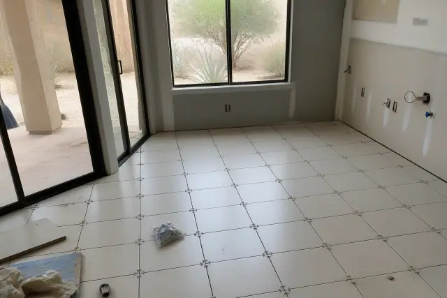 Ceramic tile installation with spacers on a kitchen floor in a west-facing room in Phoenix, AZ, with desert views.