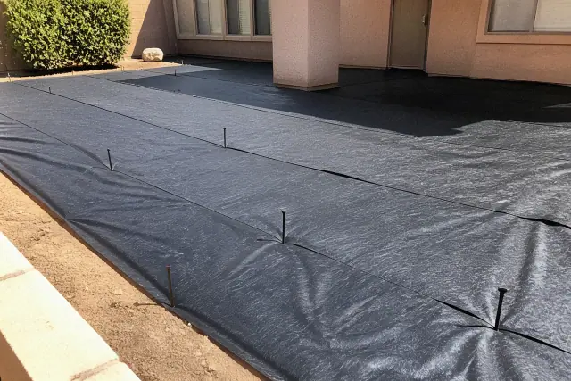 Weed barrier fabric installation for desert landscaping in Peoria, AZ.