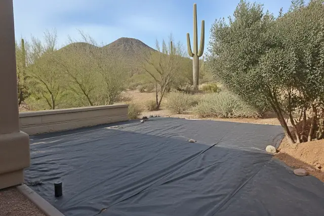 Weed barrier fabric and crushed granite landscaping at a job site in Paradise Valley, AZ with saguaro cacti.