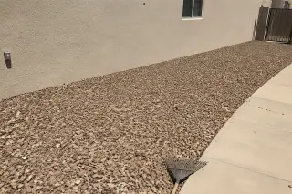 Uniform decorative rock covering a yard with clean walkway edges in Phoenix, AZ.