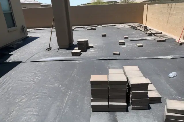 Contractor installing hardscape pavers over gravel at a residential jobsite in Phoenix, AZ.
