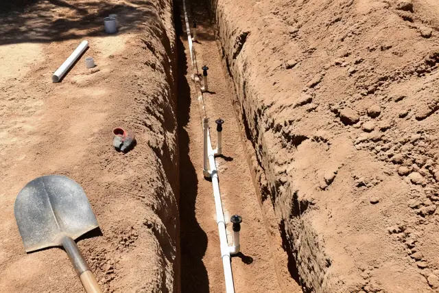 Exposed mainline and piping system in an irrigation trench during a repair in Phoenix, AZ.