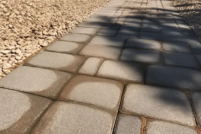 Concrete pavers with precision weed control treatment and sun-bleached gravel in Phoenix, AZ.