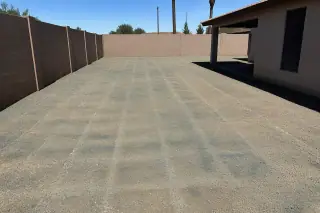 Cleared ground with blue herbicide dye and spray patterns on granite soil in Phoenix, AZ.