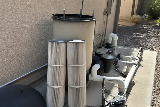 Pool filter cartridges leaning against a filtration tank during a cleaning service at a home in Phoenix, AZ.