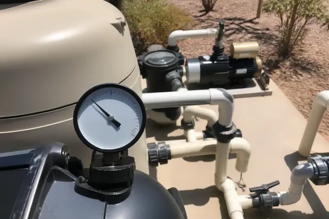 Pool filter gauge showing a clean reading on an equipment pad in Phoenix, AZ, with desert landscaping in the background.