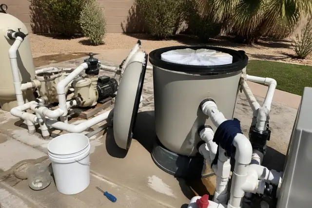 A pool filter being cleaned with fresh grids inside an open housing at a residential site in Phoenix, AZ.