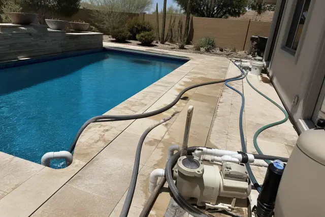 A swimming pool undergoing a drain, refill, and water rebalancing service in a residential backyard in Phoenix, AZ.