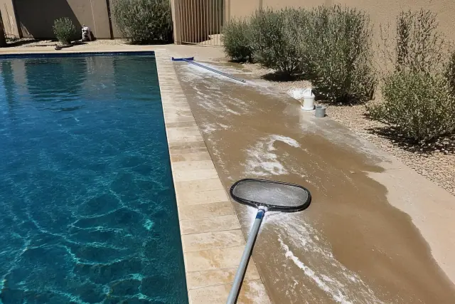 Technician cleaning a green pool with skimmer nets at a home in Gilbert, AZ.