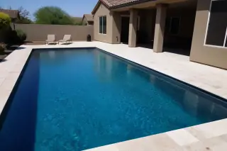 Cleaned rectangular swimming pool with deep blue water and desert landscaping in a residential backyard in Phoenix, AZ.