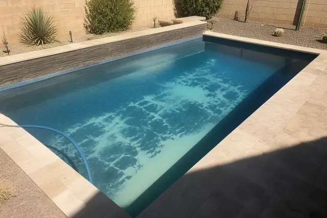 Residential swimming pool in Tempe, AZ undergoing an acid wash with visible residue patterns on the pool floor.