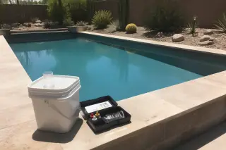 Chemical bucket and water testing kit on a rectangular pool deck in a Phoenix, AZ backyard.