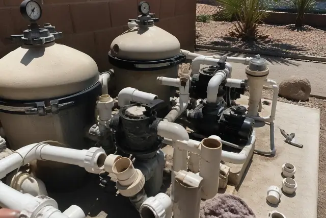 Pool equipment inspection and repair with plumbing work on a concrete slab in a Phoenix, AZ backyard.