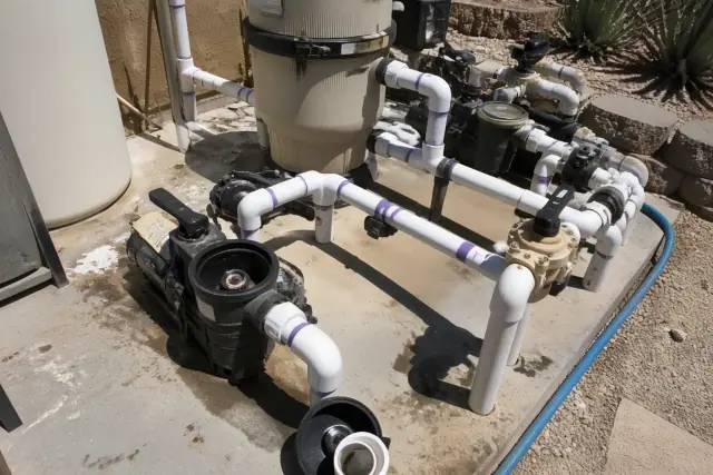 Pool filtration system and pump undergoing repair on a concrete slab in Phoenix, AZ.