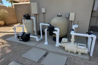 Pool filtration tanks, booster pumps, and new PVC piping at a completed repair project in Phoenix, AZ.