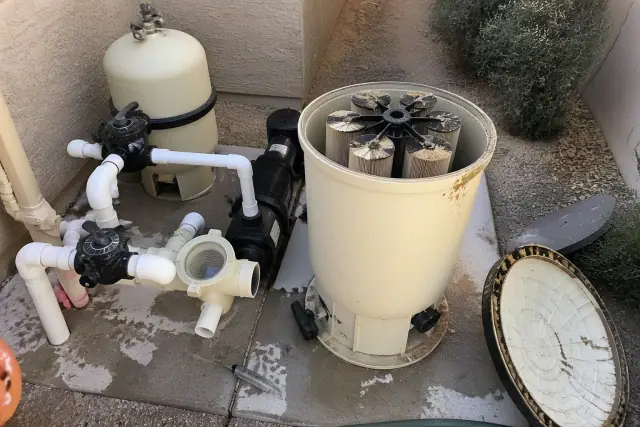 Open pool filter housing showing grid cartridges during a cleaning service at a home in Chandler, AZ.