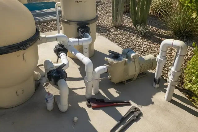 New pool pump and plumbing equipment installed on a concrete pad at a backyard in Avondale, AZ.