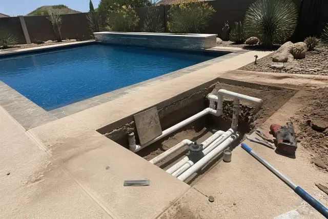 Pool repair work with plumbing tools on an opened pool deck at a residential home in Goodyear, AZ.