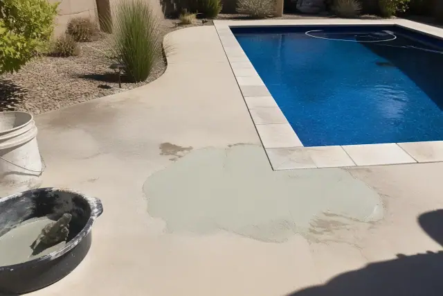 Pool repair in progress with fresh plaster and tools by a rectangular swimming pool in Chandler, AZ.