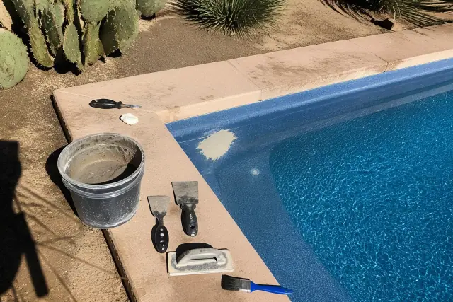 Pool repair tools and curing compound on the edge of a backyard swimming pool in Gilbert, AZ.