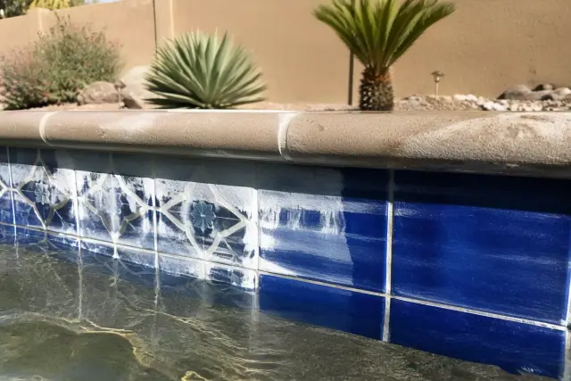 Cleaning mineral deposits from pool waterline tiles at a residential backyard in Phoenix, AZ.