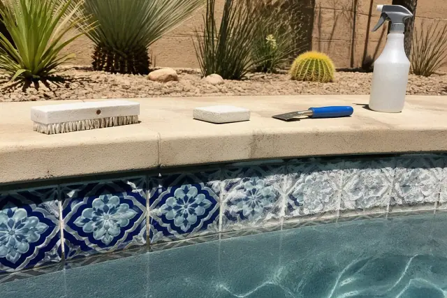 Pool tile cleaning in progress with mineral scale removal tools on a pool waterline in Mesa, AZ.