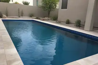 Cleaned waterline tiles on a rectangular pool in a Phoenix, AZ backyard with desert landscaping.