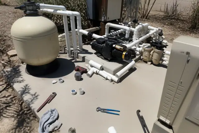 Pool repair equipment and tools being serviced on a concrete slab in Phoenix, AZ.