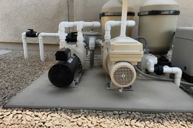 Single-speed and variable-speed pool pump motors on a concrete equipment pad in Phoenix, AZ.